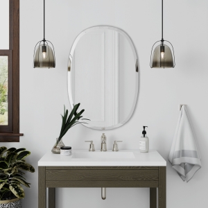 Frameless beveled oblong oval mirror hanging on bathroom wall above single sink vanity