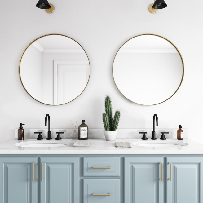 Gold metal framed round mirrors hanging on bathroom wall above double sink vanity