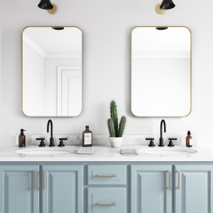 Gold metal framed rounded rectangle mirrors hanging on bathroom wall above double sink vanity