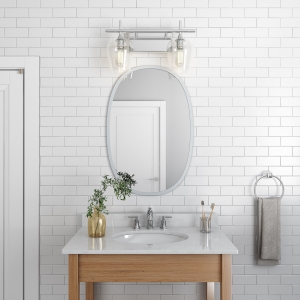 Grey rubber framed oval mirror hanging on bathroom wall above wood vanity